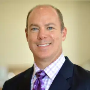 Dr. Reid Sutton in a suit and tie, smiling