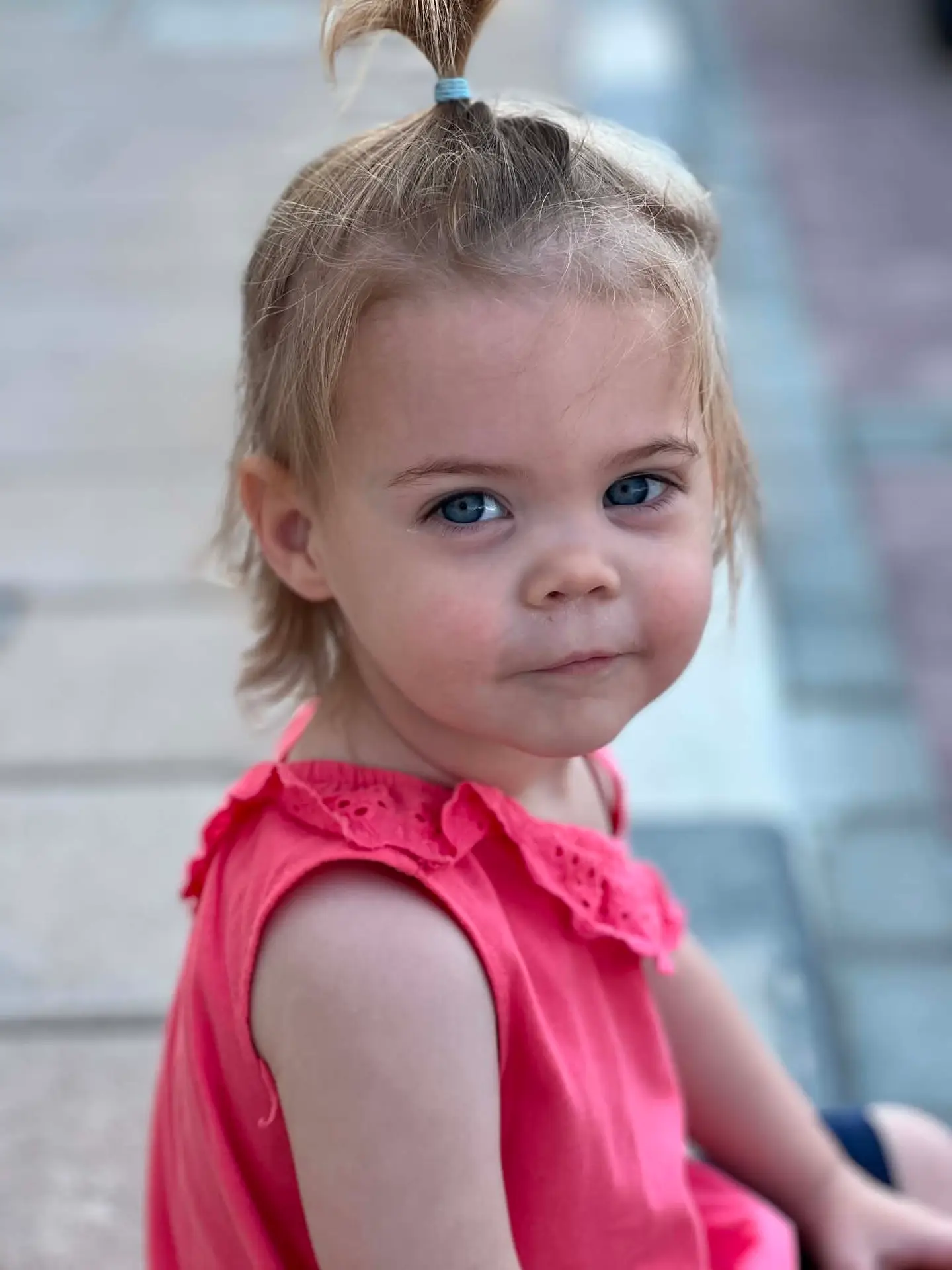 Young girl with blue eyes and blonde hair in a pink dress